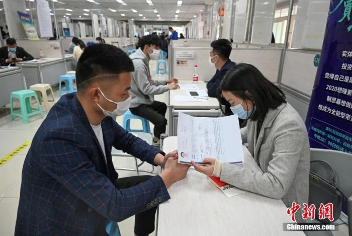 4月14日，招聘者在查看求職者簡歷。<a target='_blank'  data-cke-saved- >中新社</a>記者 王剛 攝