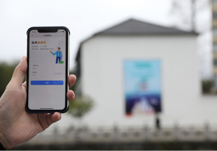 在浙江省杭州市臨安區(qū)天目山鎮(zhèn)，一名居民在“杭州健康碼”海報(bào)上掃碼申領(lǐng)個(gè)人二維碼。新華社發(fā)