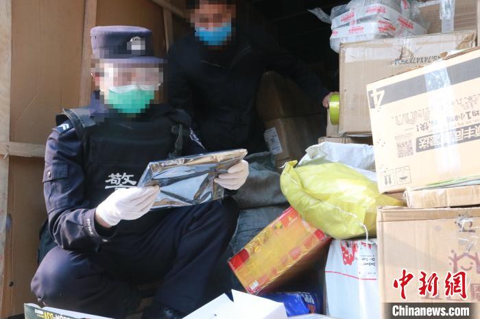 圖為勐康邊檢站民警在對快遞運(yùn)輸車輛進(jìn)行例行檢查?！钐?攝