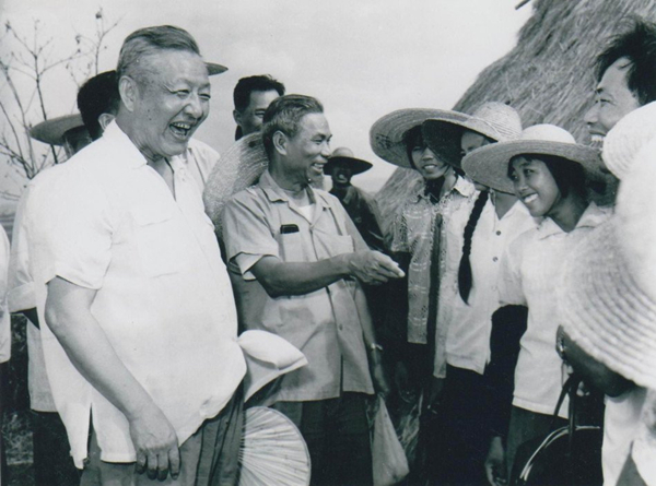 1980年8月底至9月初，習(xí)仲勛（左一）在廣東湛江農(nóng)村視察時(shí)與青年親切交談。
