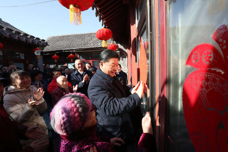 2019年2月1日上午，習(xí)近平在北京前門東區(qū)草廠四條胡同32號院，高興地拿起一幅“福”字，親自貼到門上，給這里的老街坊們拜年。新華社記者 鞠鵬 攝
