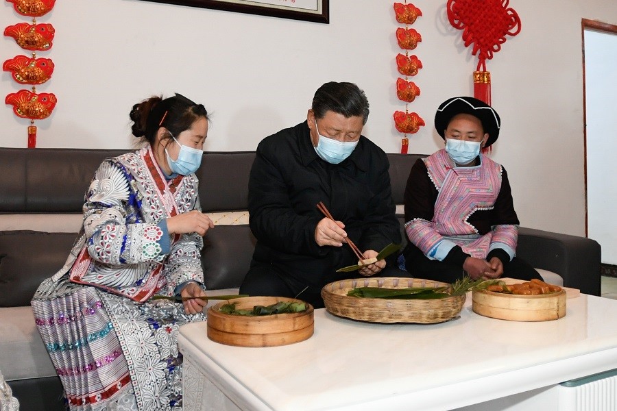 2021年2月3日下午，習近平在貴州畢節(jié)市黔西縣新仁苗族鄉(xiāng)化屋村苗族村民趙玉學家，同一家人邊聊家常邊制作當地傳統節(jié)日食品黃粑。新華社記者 李學仁 攝